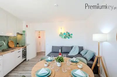 a kitchen and living room with a table and a couch at Peneco Beach Apartment Old Town in Albufeira