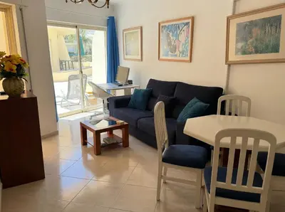 a living room with a blue couch and a table at Modern 2BR Vilamoura Stay Pool Access Golf Nearby 15 Percent Off in Quarteira