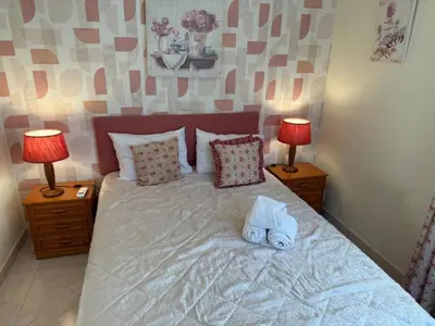 a bed with two lamps and a pair of shoes on it at Modern 2BR Vilamoura Stay Pool Access Golf Nearby 15 Percent Off in Quarteira