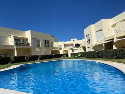 a large swimming pool in front of a building at Modern 2BR Vilamoura Stay Pool Access Golf Nearby 15 Percent Off in Quarteira