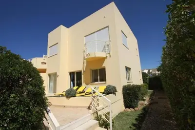 a large white house with a balcony at Modern 2BR Vilamoura Stay Pool Access Golf Nearby 15 Percent Off in Quarteira