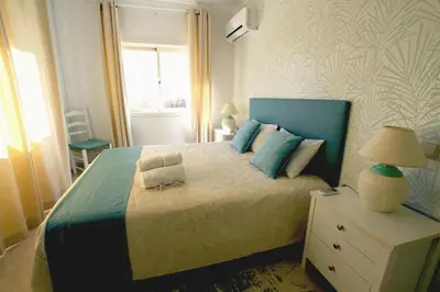 a bedroom with a large bed with a blue headboard at Modern 2BR Vilamoura Stay Pool Access Golf Nearby 15 Percent Off in Quarteira