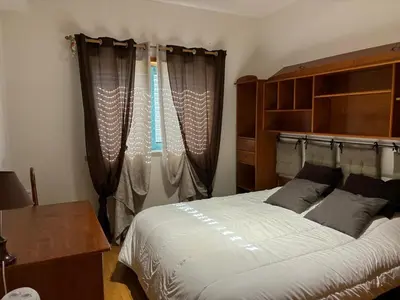 a bedroom with a bed and a window with curtains at Marina Paradis Bleu in Albufeira