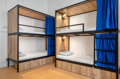 two bunk beds in a room with blue curtains at Plaza Inn Hostel & Rooms in Faro