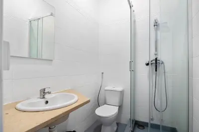 a bathroom with a toilet and a sink and a shower at Plaza Inn Hostel & Rooms in Faro