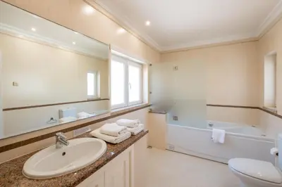 a bathroom with a sink and a tub and a mirror at Pedro Mar by Atlantic Places in Albufeira