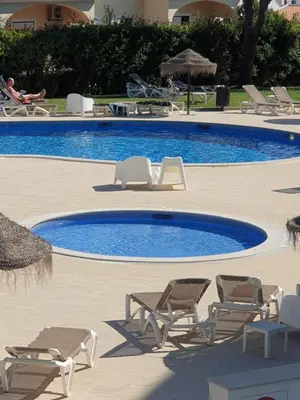 a swimming pool with lounge chairs and a swimming pool at Vista das Ondas in Albufeira