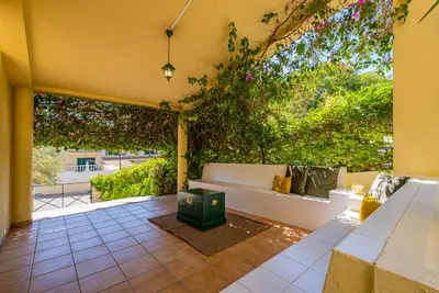 a patio with a white bench and plants at Retiro dos Calicos by Dreamplaces in Albufeira