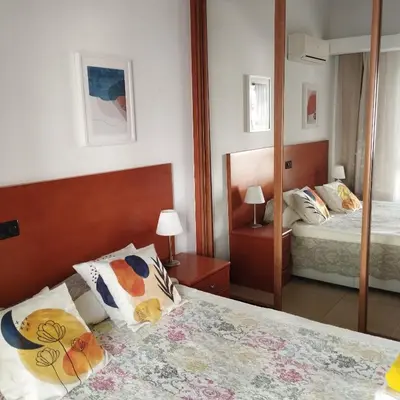 a bedroom with two beds and a mirror at 1- bedroom flat in Vilamoura near the beach in Vilamoura