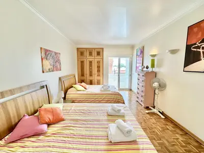 a bedroom with two beds and a dresser at Apartamento 10 min da praia in Albufeira