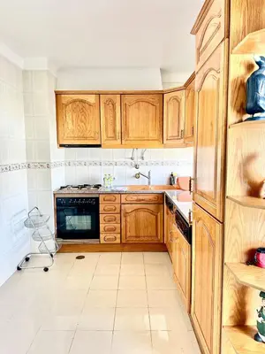 a kitchen with wooden cabinets and a sink at Apartamento 10 min da praia in Albufeira