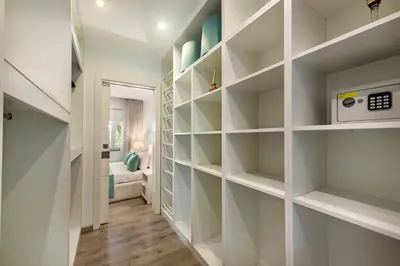 a walk in closet with white shelves at Casa dos Quatro in Faro