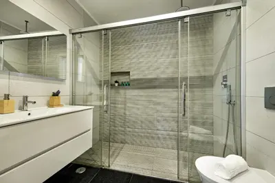 a bathroom with a glass shower with a toilet and a sink at Casa dos Quatro in Faro