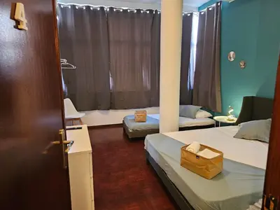 a room with two beds and a door with a bag on it at Blife Lusitanya - private rooms at Santantonya 1st floor in Faro