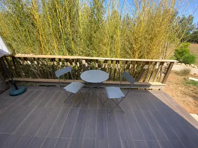 a patio with a table and chairs on a deck at Quinta Oriana Bella suite in Paderne