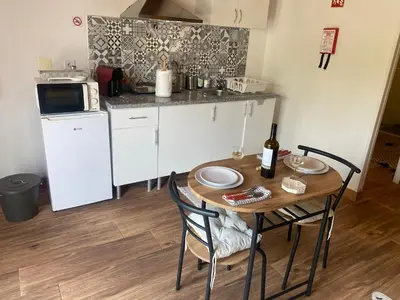 a small kitchen with a wooden table and a table and chairs at Quinta Oriana Bella suite in Paderne