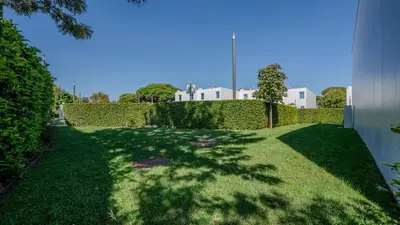 a garden with a hedge and a building in the background at Central Vilamoura Casa A in Quarteira