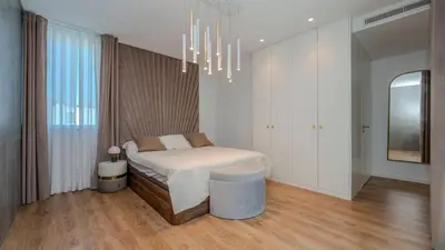 a white bedroom with a bed and a chandelier at Central Vilamoura Casa A in Quarteira