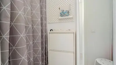 a bathroom with a shower curtain and a refrigerator at Central Vilamoura Casa A in Quarteira