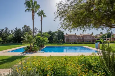 a swimming pool in front of a house with palm trees at Sunny House with Jacuzzi and Pool by HostWise in Albufeira