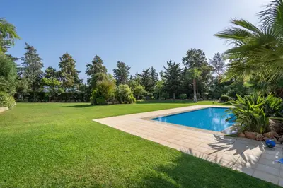 a backyard with a swimming pool and a lawn at Sunny House with Jacuzzi and Pool by HostWise in Albufeira