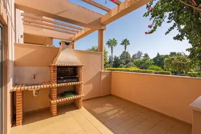 a patio with an outdoor oven on a balcony at Sunny House with Jacuzzi and Pool by HostWise in Albufeira