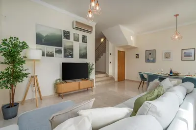 a living room with a white couch and a television at Sunny House with Jacuzzi and Pool by HostWise in Albufeira