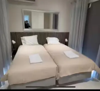 two beds in a hotel room with a mirror at Pine Hills Vilamoura in Quarteira
