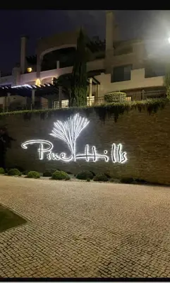 a neon sign that says peace of us on a wall at Pine Hills Vilamoura in Quarteira