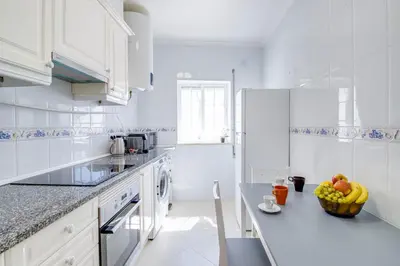 a white kitchen with a bowl of fruit on a counter at Charming Old Town 1BR 50m from Beach AC Wi-Fi Parking in Albufeira