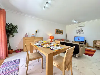 a dining room and living room with a table and chairs at Vilamoura Victoria Boulevard With Pool by Homing in Vilamoura