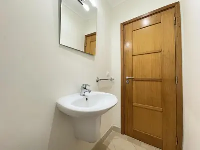 a bathroom with a sink and a wooden door at Vilamoura Victoria Boulevard With Pool by Homing in Vilamoura