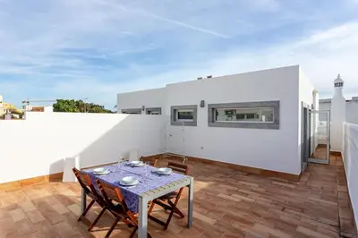 a dining room with a table and chairs on a balcony at Blife Galya private house in Faro