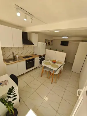 a kitchen with white cabinets and a table and chairs at Santos Studio in Faro