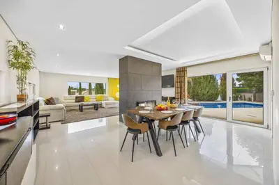 a kitchen and living room with a table and chairs at Villa Caripira by Villa Plus in Albufeira