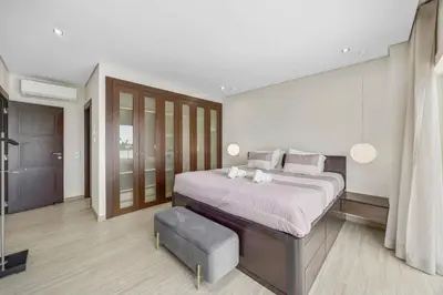 a large bedroom with a large bed and a stool at Villa Caripira by Villa Plus in Albufeira