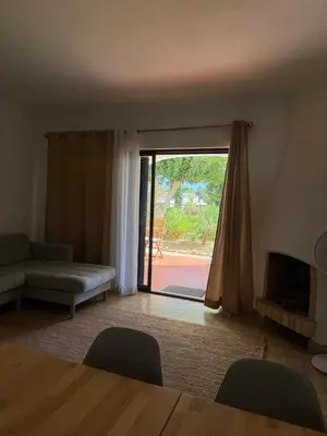 a living room with a couch and a sliding glass door at Lemon Beach House - São Rafael in Albufeira