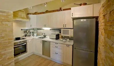 a kitchen with white cabinets and a stainless steel refrigerator at Perfect To Relax in Algoz