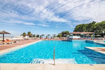 a large swimming pool with chairs and umbrellas at White Studio and Terrace in Albufeira