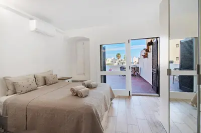 a bedroom with a bed and a view of the ocean at White Studio and Terrace in Albufeira