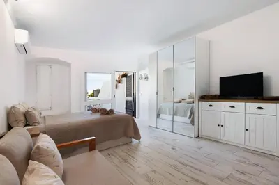 a living room with a bed and a television at White Studio and Terrace in Albufeira