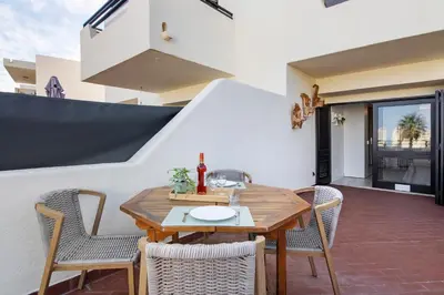 a patio with a wooden table and chairs at White Studio and Terrace in Albufeira