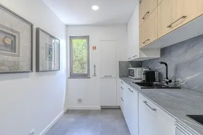 a kitchen with white cabinets and a sink and a window at #335 Recanto do Manaca by Home Holidays in Guia