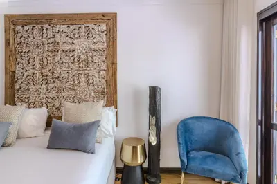 a bedroom with a bed and a blue chair at #335 Recanto do Manaca by Home Holidays in Guia
