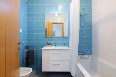 a bathroom with a sink and a toilet and a mirror at Quarteira Modern Flat in Quarteira