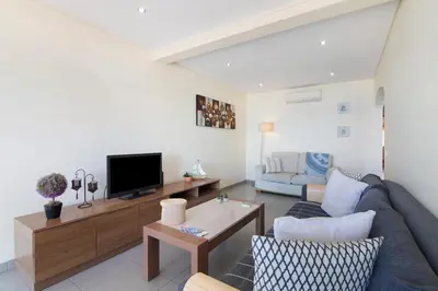 a living room with a couch and a tv at Quarteira Modern Flat in Quarteira