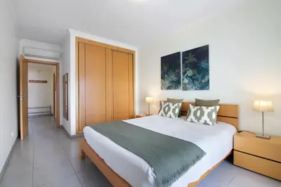 a bedroom with a large white bed with two pillows at Quarteira Modern Flat in Quarteira