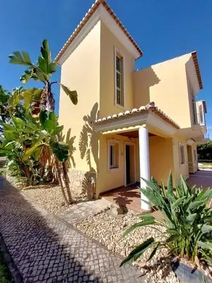 a yellow house with some plants in front of it at Vilapeti by SAPvillas in Quarteira