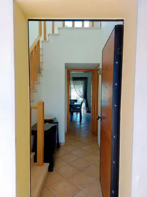 a hallway with a door leading to a room with a staircase at Vilapeti by SAPvillas in Quarteira