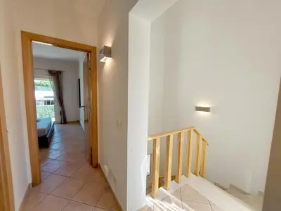 a hallway with a staircase leading to a living room at Vilapeti by SAPvillas in Quarteira